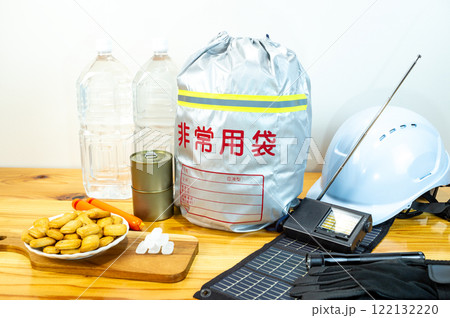 防災用品と一緒に並べられた乾パンと氷砂糖と魚肉ソーセージと缶詰と飲料水 122132220