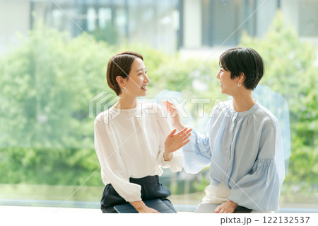 窓辺に座って話すビジネスウーマン 122132537
