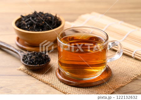Black tea in cup glass with dried tea leaves, Healthy herbal drink 122132632