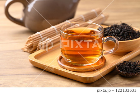 Black tea in cup glass with dried tea leaves, Healthy herbal drink 122132633