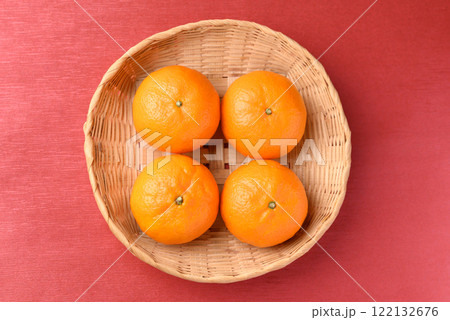 Mandarin tangerine orange fruit in basket on red background, Lucky food in Lunar New Year 122132676