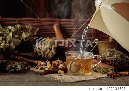 Cup of herbal tea with various dried herbs, flowers, and spices. 122132731