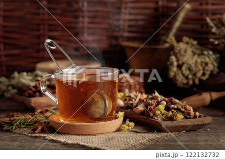 Cup of herbal tea with various dried herbs, flowers, and spices. 122132732