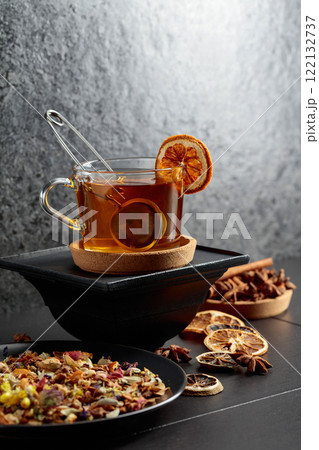 Cup of herbal tea with ingredients and slices of dried orange slices. 122132737