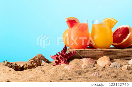 Grapefruit and orange cocktails with ice on a beach. 122132740