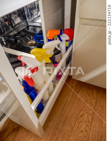 kitchen cabinet with a variety of cleaning supplies organized on pull-out shelf. High quality photo 122134718