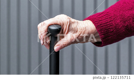 Elderly woman holding walking stick 122135711