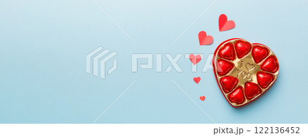 Delicious chocolate pralines in red box for Valentine's Day. Heart shaped box of chocolates top view with copy space 122136452