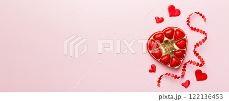 Delicious chocolate pralines in red box for Valentine's Day. Heart shaped box of chocolates top view with copy space 122136453