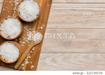 A wooden bowl of salt crystals on a wooden background. Salt in rustic bowls, top view with copy space A wooden bowl of salt crystals on a wooden background. Salt in rustic bowls, top view with copy space 122136539