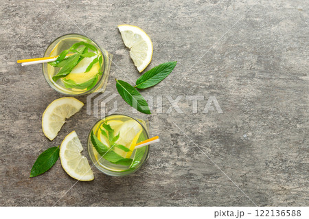 Caipirinha, Mojito cocktail, vodka or soda drink with lime, mint and straw on table background. Refreshing beverage with mint and lime in glass top view flat lay 122136588