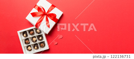 Delicious chocolate pralines in red box for Valentine's Day. Heart shaped box of chocolates top view with copy space 122136731