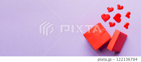 Happy valentines day opened heart shape gift box with small hearts, on colored background, valentines day card - top view concept 122136784