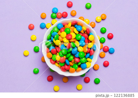 Multicolored candies in a bowl on a colored background. birthday and holiday concept. Top view with copy space Multicolored candies in a bowl on a colored background. birthday and holiday concept. Top view with copy space 122136885