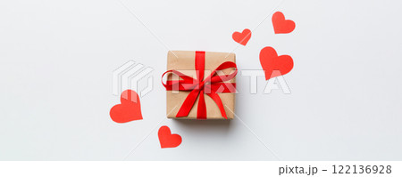 Valentine day composition Background: red gift box with bow and heart. Christmas present. View from above. Holday greeting card Valentine day composition Background: red gift box with bow and heart. Christmas present. View from above. Holday greeting card 122136928