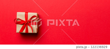 Valentine day composition: red gift box with bow and heart. Christmas present. View from above. Space for text. Holday greeting card 122136929