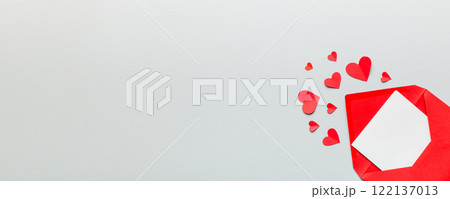 Red paper envelope with empty white card and heart on colored background. top view valentines day concept Red paper envelope with empty white card and heart on colored background. top view valentines day concept 122137013