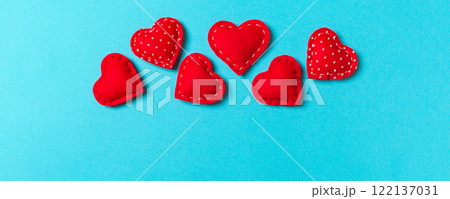 Composition of textile red hearts on colorful background with empty space for your design. Top view of St. Valentine's day concept 122137031