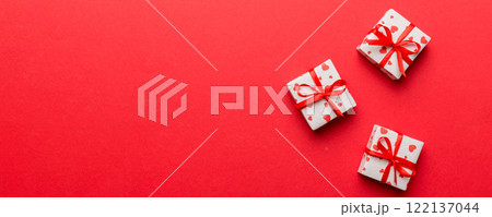 Valentine day composition: red gift box with bow and heart. Christmas present. View from above. Space for text. Holday greeting card 122137044