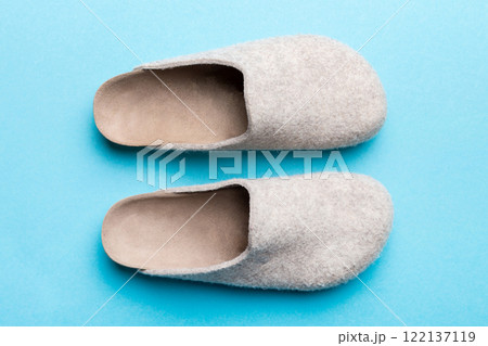 Warm winter women woolen slippers on colored background. Copy space for text Warm winter women woolen slippers on colored background. Copy space for text 122137119