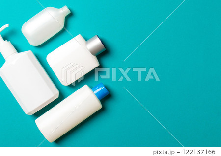 Set of White Cosmetic containers isolated on colored background, top view with copy space. Group of plastic bodycare bottle containers with empty space for you design 122137166
