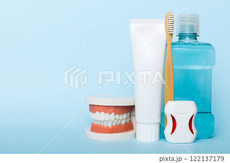 Mouthwash and other oral hygiene products on colored table top view with copy space. Flat lay. Dental hygiene. Oral care kit. Dentist concept Mouthwash and other oral hygiene products on colored table top view with copy space. Flat lay. Dental hygiene. Oral care kit. Dentist concept 122137179