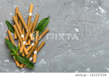 Menthol cigarettes and fresh mint leaves on colored background, Many cigarettes stacked together top view flat lay 122137239