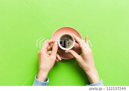 Minimalistic style woman hand holding a cup of coffee on Colored background. Flat lay, top view cappuccino cup. Empty place for text, copy space. Coffee addiction. Top view, flat lay Minimalistic style woman hand holding a cup of coffee on Colored background. Flat lay, top view cappuccino cup. Empty place for text, copy space. Coffee addiction. Top view, flat lay 122137249
