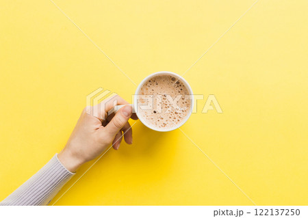 Minimalistic style woman hand holding a cup of coffee on Colored background. Flat lay, top view cappuccino cup. Empty place for text, copy space. Coffee addiction. Top view, flat lay Minimalistic style woman hand holding a cup of coffee on Colored background. Flat lay, top view cappuccino cup. Empty place for text, copy space. Coffee addiction. Top view, flat lay 122137250