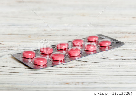 Blister package with Vitamin on color background. Medicine pills on a light background. Medicines and prescription pills flat lay background. pink medical tablets in blister 122137264