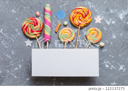 Flat lay holiday composition. Paper blank, lollipop, birthday decorations on Colored background. Top view, copy space for text Flat lay holiday composition. Paper blank, lollipop, birthday decorations on Colored background. Top view, copy space for text 122137275