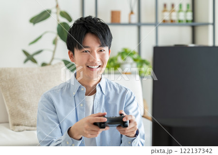 テレビゲームをする若い男性 122137342