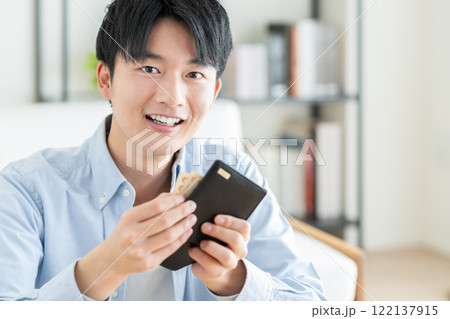 財布を持つ若い男性 122137915