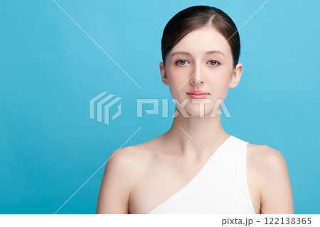 Beautiful young woman with clean fresh skin on blue background, Face care, Facial treatment, Cosmetology, beauty and spa, women portrait. Beautiful young woman with clean fresh skin on blue background, Face care, Facial treatment, Cosmetology, beauty and spa, women portrait. 122138365