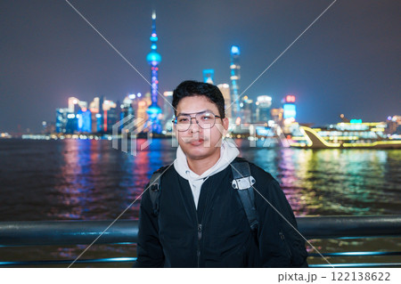 Man traveler visiting in Shanghai, China. Male Tourist with backpack sightseeing Shanghai view of Lujiazui in The Bund of Shanghai at night. landmark and popular for tourism attractions Man traveler visiting in Shanghai, China. Male Tourist with backpack sightseeing Shanghai view of Lujiazui in The Bund of Shanghai at night. landmark and popular for tourism attractions 122138622