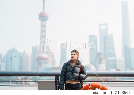 woman traveler visiting in Shanghai, China. Female Tourist with backpack sightseeing Shanghai view of Lujiazui in The Bund of Shanghai. landmark and popular for tourism attractions. Vacation concept woman traveler visiting in Shanghai, China. Female Tourist with backpack sightseeing Shanghai view of Lujiazui in The Bund of Shanghai. landmark and popular for tourism attractions. Vacation concept 122138661