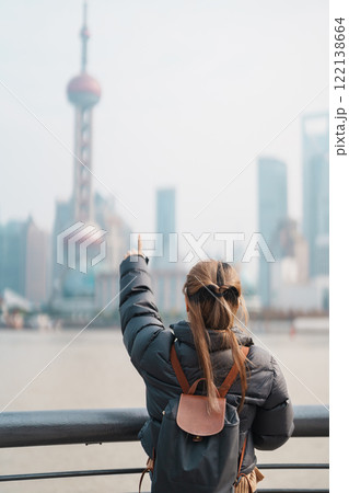 woman traveler visiting in Shanghai, China. Female Tourist with backpack sightseeing Shanghai view of Lujiazui in The Bund of Shanghai. landmark and popular for tourism attractions. Vacation concept woman traveler visiting in Shanghai, China. Female Tourist with backpack sightseeing Shanghai view of Lujiazui in The Bund of Shanghai. landmark and popular for tourism attractions. Vacation concept 122138664