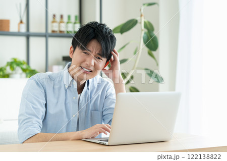 リビングでパソコンを使う若い男性 122138822