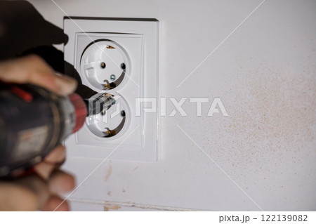 Close-Up of Electrical Outlet Installation with Power Tool 122139082