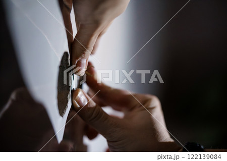 Close-up of Hands Removing a Sticker from a Surface Close-up of Hands Removing a Sticker from a Surface 122139084