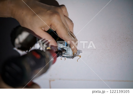 Electrical Installation: A Close-Up of Hands Installing a Wall Outlet 122139105
