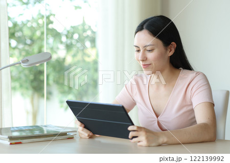 Asian woman watching media on tablet in a room 122139992