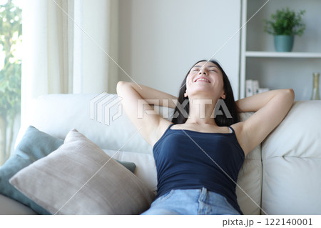 Happy relaxed asian woman resting sitting at home Happy relaxed asian woman resting sitting at home 122140001