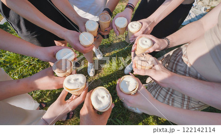 Friends holding ice cream cones in a circle on a sunny day Friends holding ice cream cones in a circle on a sunny day 122142114