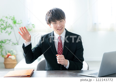 デスクに座ってパソコンを使うビジネスマン デスクに座ってパソコンを使うビジネスマン 122143772