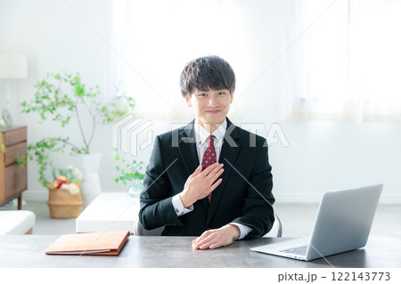 デスクに座ってパソコンを使うビジネスマン デスクに座ってパソコンを使うビジネスマン 122143773