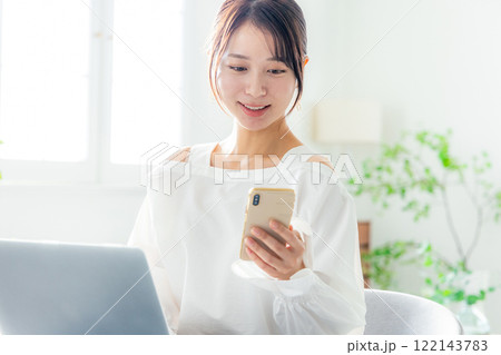 ノートパソコン スマホを見る女性 ノートパソコン スマホを見る女性 122143783