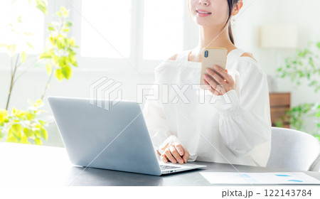 ノートパソコン　スマホを見る女性 122143784