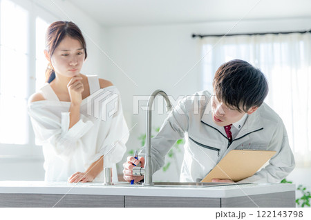 作業服の男性と悩む若い女性 作業服の男性と悩む若い女性 122143798