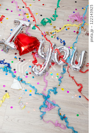 Confetti, streamers and foil balloon I Love You are lying on the floor. 122143925